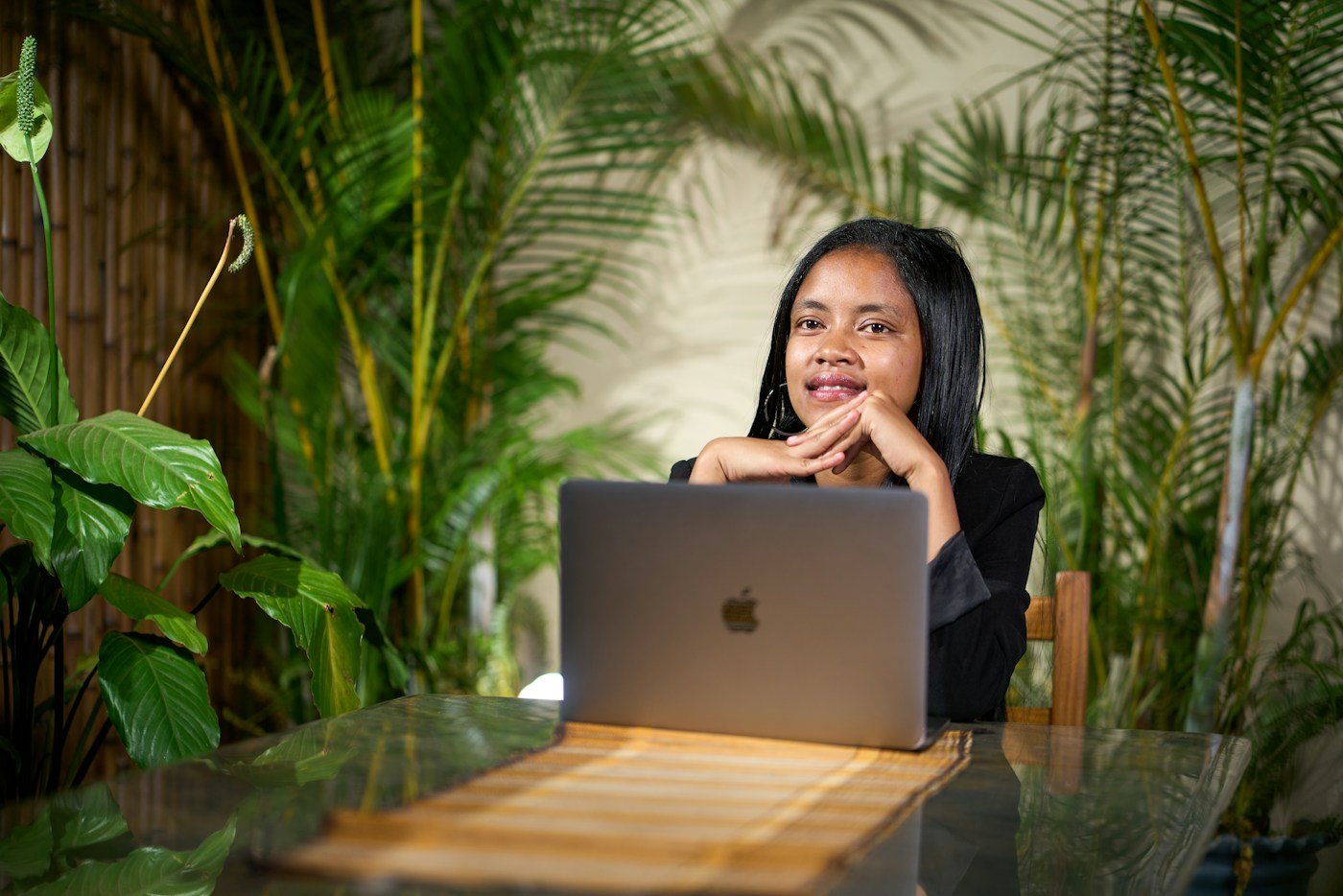Criadora de conteúdo sorrindo atrás do notebook