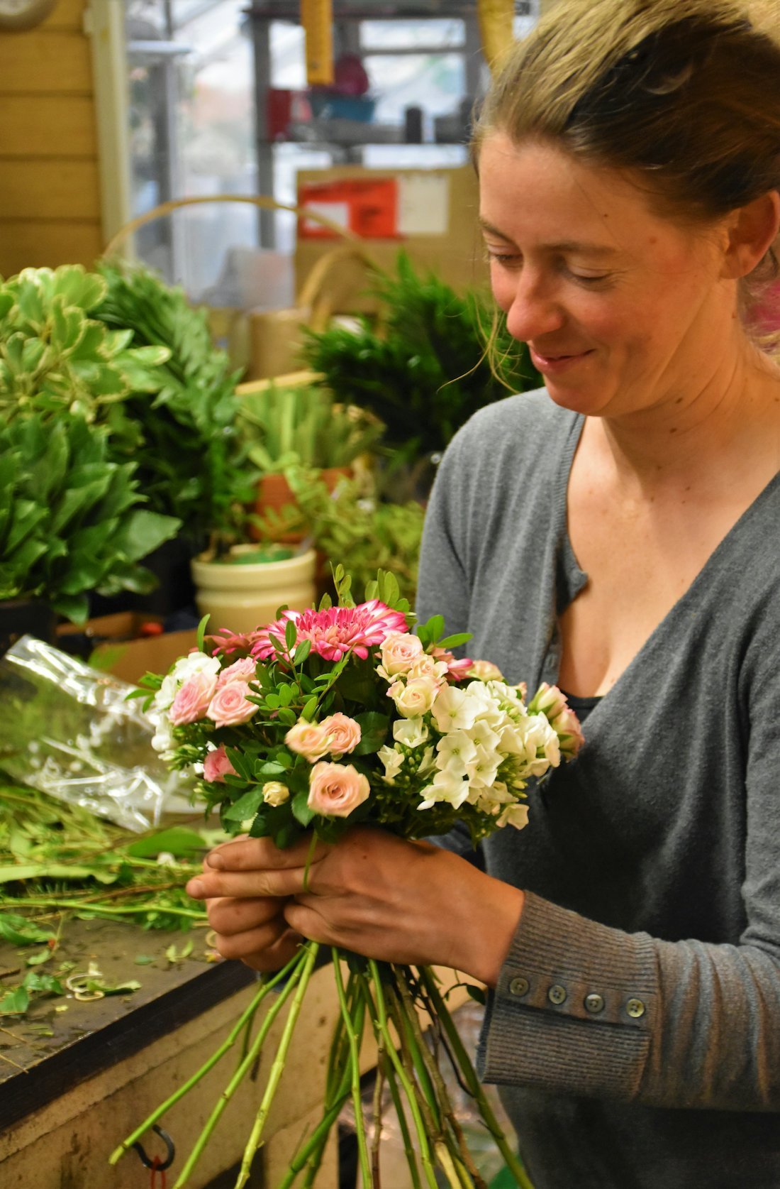 Florista montando um buquê na sua floricultura